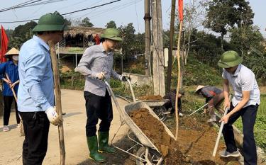 Bí thư Huyện ủy Yên Bình An Hoàng Linh (đứng giữa) tham gia vệ sinh môi trường, trồng hoa trong “Ngày cuối tuần cùng dân” tại thôn Loan Thượng, xã Tân Hương.