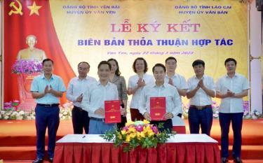 Bí thư Huyện ủy Văn Yên Luyện Hữu Chung và Bí thư Huyện ủy Văn Bàn Phí Công Hoan ký kết biên bản thỏa thuận hợp tác.