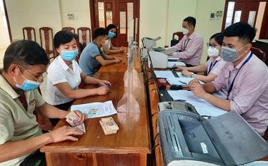 Người dân nhận vốn vay của Phòng Giao dịch Ngân hàng Chính sách xã hội huyện Yên Bình tại điểm giao dịch xã Thịnh Hưng.