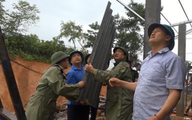 Lãnh đạo huyện Trạm Tấu và Ủy ban Mặt trận Tổ quốc huyện tham gia làm nhà cho hộ nghèo ở xã Pá Lau.