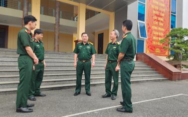 Thượng tá Trần Xuân Hướng (người đứng giữa) trao đổi nghiệp vụ về công tác dân vận với cán bộ cùng cơ quan.
