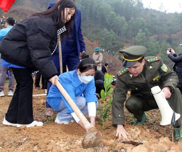 Cán bộ Hạt Kiểm lâm huyện Văn Chấn hướng dẫn người dân kỹ thuật trồng rừng.