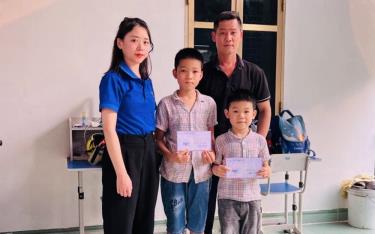 Hai anh em Hà Mạnh Hùng và Hà Duy Minh - Trường Tiểu học Kim Đồng, thành phố Yên Bái nhận quà của nhà tài trợ.