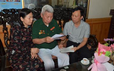 Ông Lê Văn Chiến cùng cán bộ Hội Cựu chiến binh thị xã Nghĩa Lộ và con gái xem lại những trang nhật ký chiến trường mà ông đã lưu giữ.