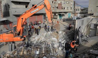 Lực lượng cứu hộ tìm kiếm các nạn nhân trong đống đổ nát sau vụ oanh tạc của Israel xuống thành phố Rafah, miền Nam Dải Gaza, ngày 19/4/2024. Ảnh: THX/TTXVN