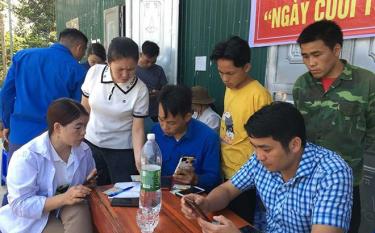Cán bộ các ban ngành, đoàn thể huyện Mù Cang Chải hướng dẫn người dân cài đặt và sử dụng ứng dụng công dân số YenBai-S.