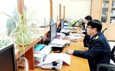 Cán bộ Chi cục Thuế huyện Yên Bình hướng dẫn người dân sử dụng 1 mã số thuế duy nhất.