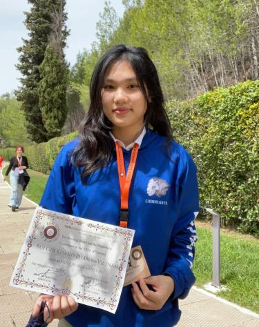 Gia Khanh trong khuôn viên của Học viện Olympic quốc tế IOA (Hy Lạp), trên tay Khanh là giấy chứng nhận giải Honorable Mention, tháng 5/2023. Ảnh: Nhân vật cung cấp
