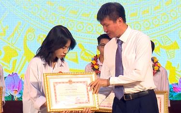 Chairman of the provincial People's Committee Tran Huy Tuan awards certificates of merit from prize winning students in the national excellent student contest.