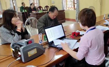 Cán bộ Phòng giao dịch Ngân hàng Chính sách xã hội huyện Lục Yên giải ngân cho người dân xã Liễu Đô.