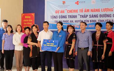 Em Trần Mỹ Anh (áo xanh ở giữa) hỗ trợ công trình 1,5 km điện đường Thắp sáng đường quê tại xã Phúc An, huyện Yên Bình.