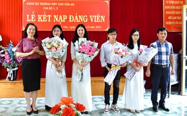 Lãnh đạo huyện Văn Yên tặng hoa chúc mừng các học sinh Trường THPT Chu Văn An được kết nạp Đảng.