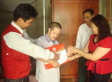 Đại diện Hội Chữ thập đỏ tỉnh Yên Bái tặng quà, động viên nạn nhân Nguyễn Hồng Văn, thị trấn Yên Thế.