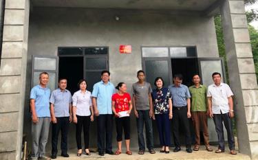 Representatives of the Standing Committee of the provincial Fatherland Front present financial support to the family of Ha Van At in Nghia Lo’s Son A commune.