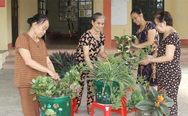 Bà Phạm Thị Mận (bên trái) cùng hội viên sử dụng phế liệu nhựa tái chế thành các chậu hoa xinh xắn, với kiểu dáng, màu sắc khác nhau.