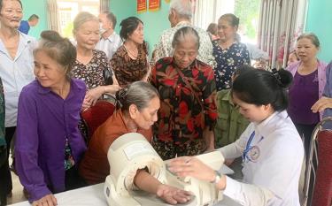 Cán bộ Trung tâm Y tế huyện Trấn Yên khám và chăm sóc sức khỏe cho người cao tuổi tại hộ gia đình.