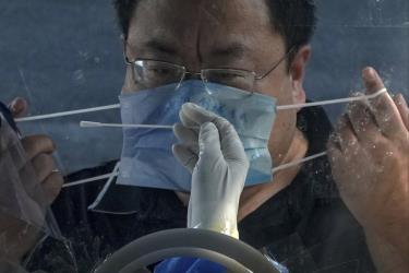 Người đàn ông tháo khẩu trang để xét nghiệm virus SARS-CoV-2 ở Bắc Kinh, Trung Quốc.