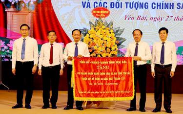 Vice Secretary of the provincial Party Committee Ta Van Long presents a flag to the VBSP’s chapter in Yen Bai.