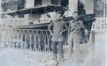 Ông Phạm Trung Tốn (trái) và ông Nguyễn Văn Tiến bên chiếc ca nô lai dắt phà đầu tiên trên bến Âu Lâu.