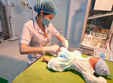 Nữ hộ sinh Khoa Chăm sóc sức khỏe sinh sản và Phụ sản, Trung tâm Y tế thành phố Yên Bái thực hiện sàng lọc sau sinh để phát hiện bệnh di truyền từ bố, mẹ sang con.