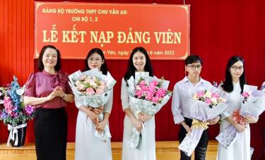 Đồng chí Vũ Minh Huê - Phó Bí thư Thường trực Huyện ủy Văn Yêntặng hoa chúc mừng các học sinh Trường THPT Chu Văn An được kết nạp Đảng.