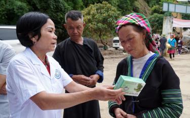 Cán bộ Trạm Y tế xã Hồ Bốn, huyện Mù Cang Chải hướng dẫn người dân sử dụng thuốc và tuyên truyền phòng dịch bệnh sau lũ.