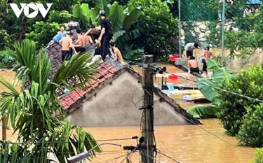 Học sinh ở thị trấn Tân Lạc, huyện Qùy Châu dỡ mái nhà trọ thoát ra ngoài khi nước dâng cao.