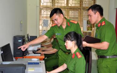 Trung tá Vũ Xuân Thành (người trong) chỉ đạo cán bộ công an phường thực hiện công tác thu thập, cập nhật, khai thác hệ thống dữ liệu quốc gia về dân cư.