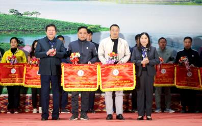 Vice Chairman of the provincial People's Committee Vu Thi Hien Hanh and Director of the provincial Department of Education and Training Vuong Van Bang present the flags honouring teams with the best performance to the Yen Bai city’s Department of Education and Training, and the provincial Ethnic Boarding High School.